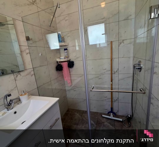 חדר אמבטיה עם מקלחון, כיור ומראה